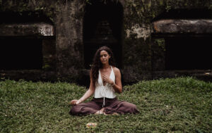 Woman meditating in front of ancient temple ruins near Talalla Retreat, Sri Lanka
