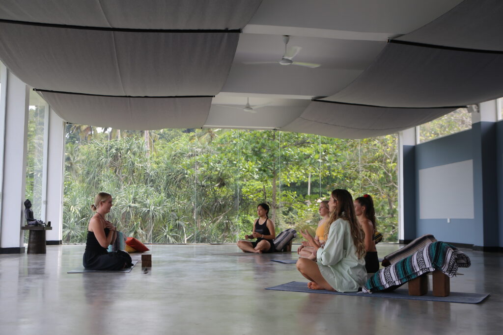 Trainees and teacher seated in the jungle-view shala during yoga teacher training at Talalla Retreat, Sri Lanka