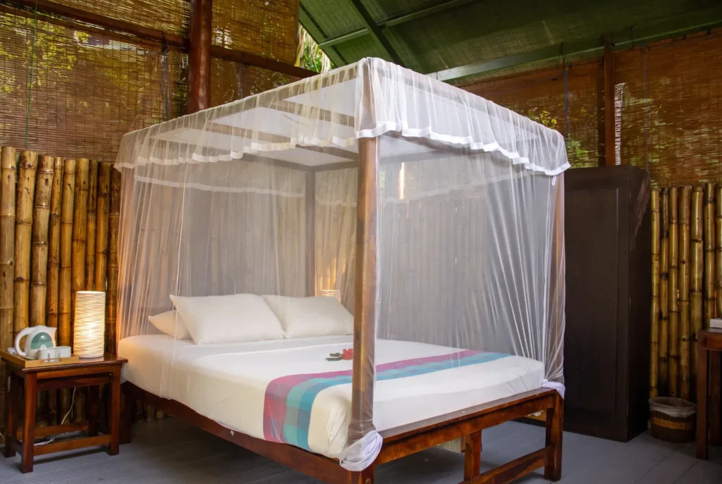 Canopy bed in a bamboo-walled room at Talalla Retreat