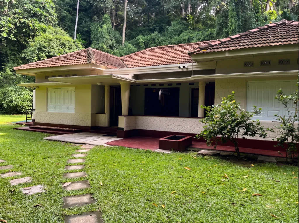 Bungalow exterior with a garden lawn at Talalla Retreat