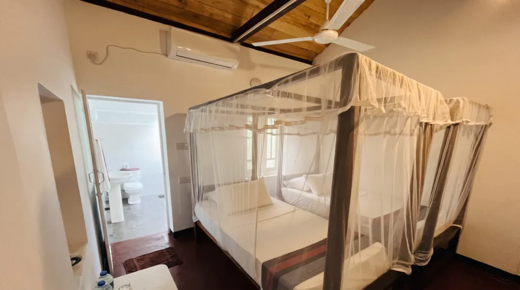 Canopy bed with mosquito net in a guest room at Talalla Retreat