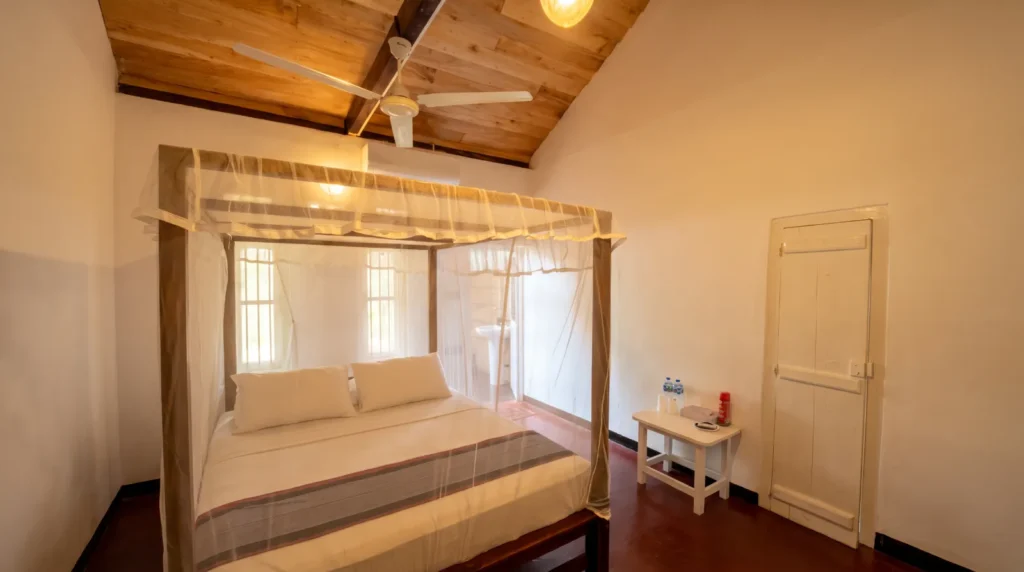 Four-poster bed under a timber ceiling in a guest room at Talalla Retreat