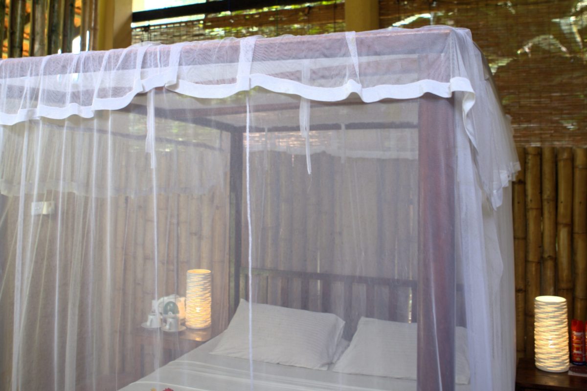 Four-poster bed with mosquito netting inside an open-sided bamboo hut at Talalla Retreat, Sri Lanka