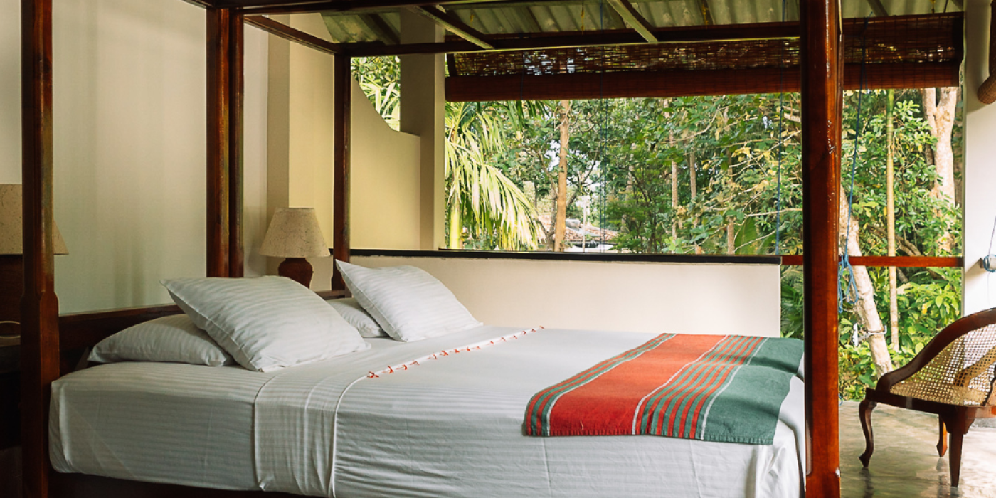 "Deluxe first-floor room with a four-poster bed at Talalla Retreat, Sri Lanka