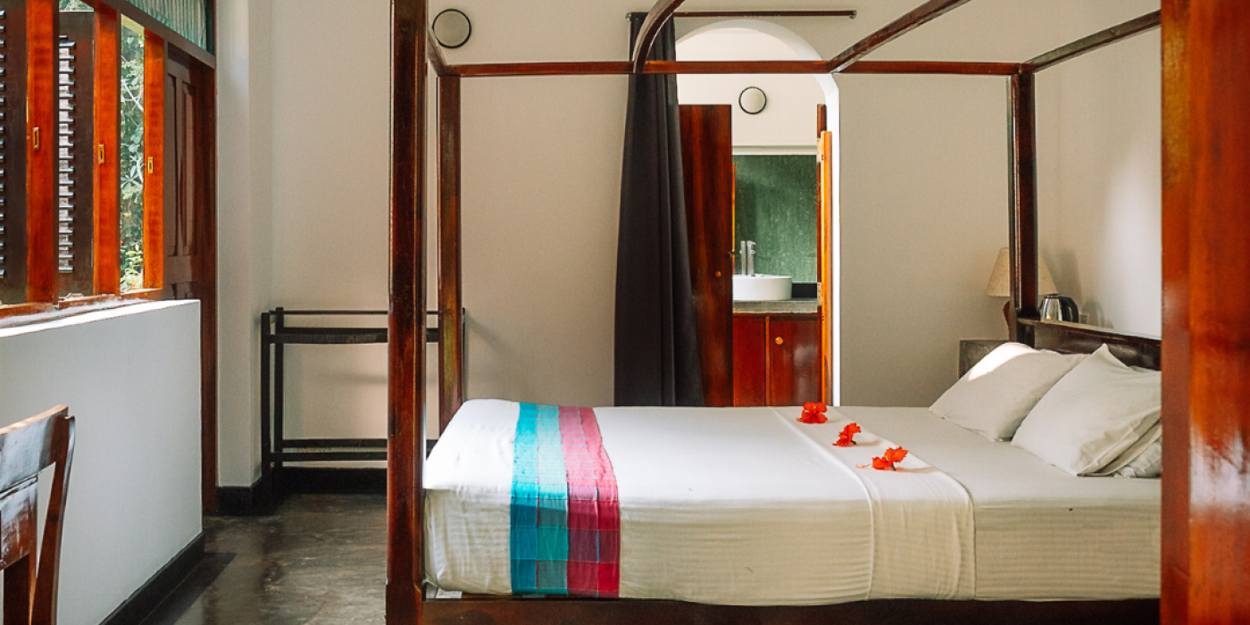 Deluxe ground-floor room with a four-poster bed at Talalla Retreat, Sri Lanka